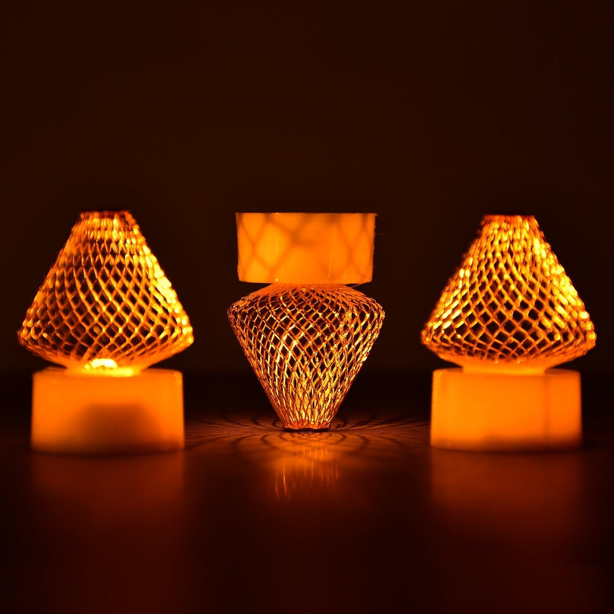 A close-up view of multiple Flameless LED Tea Light Candles glowing warmly on a dark surface.