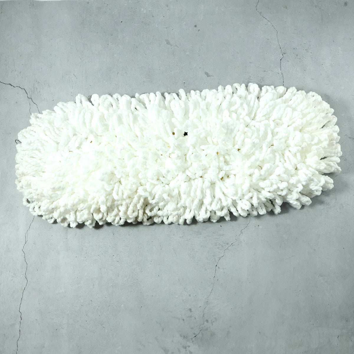 Freshly washed dust mop refill head drying naturally.
