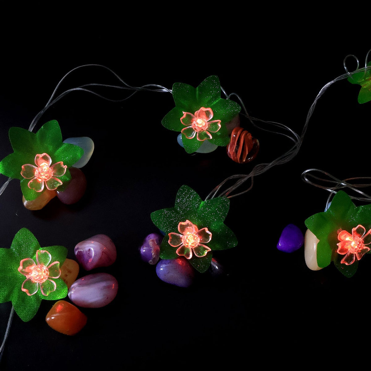Close view of multi-color LED decorative string light showcasing leaf and flower motifs