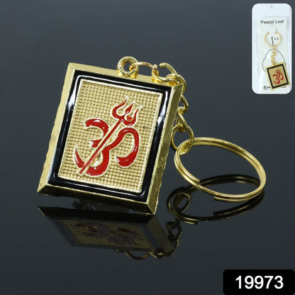 Close-up of metal keychain featuring Om Trishul symbol in golden finish